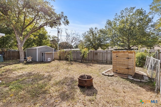 view of yard with a fire pit and a storage unit