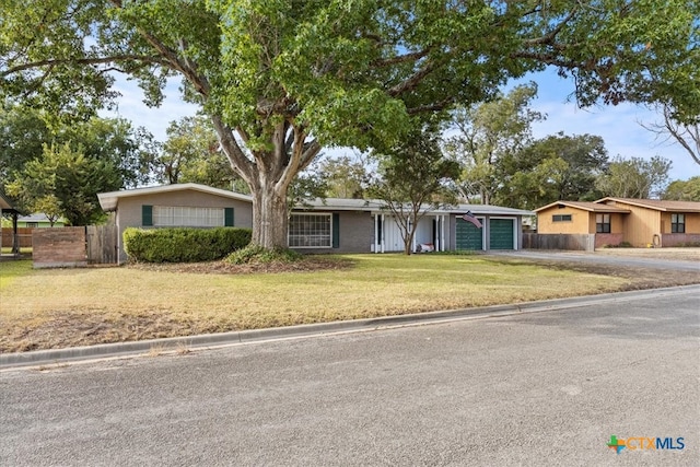 single story home with a garage and a front yard