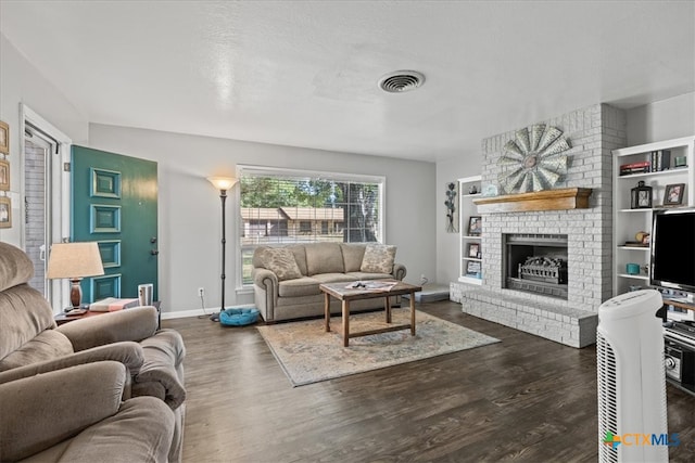 living room featuring dark hardwood / wood-style flooring, a textured ceiling, and a fireplace