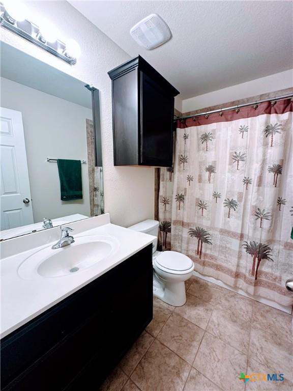 bathroom featuring curtained shower, toilet, and vanity