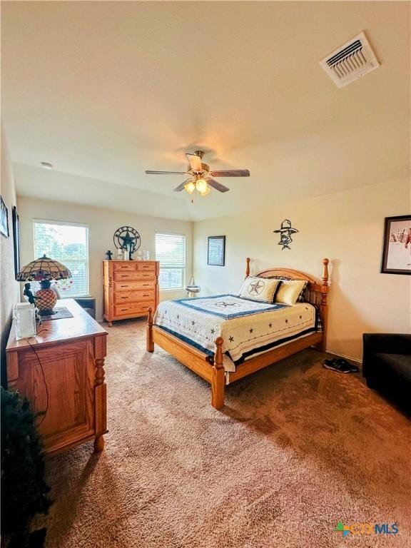 bedroom with a ceiling fan, visible vents, and carpet floors