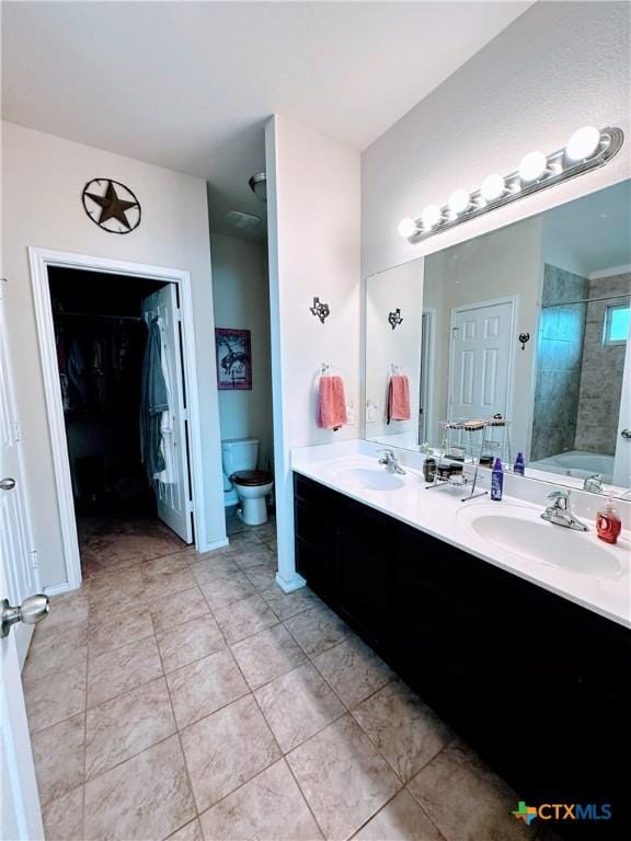 full bathroom featuring toilet, tile patterned floors, a sink, and double vanity