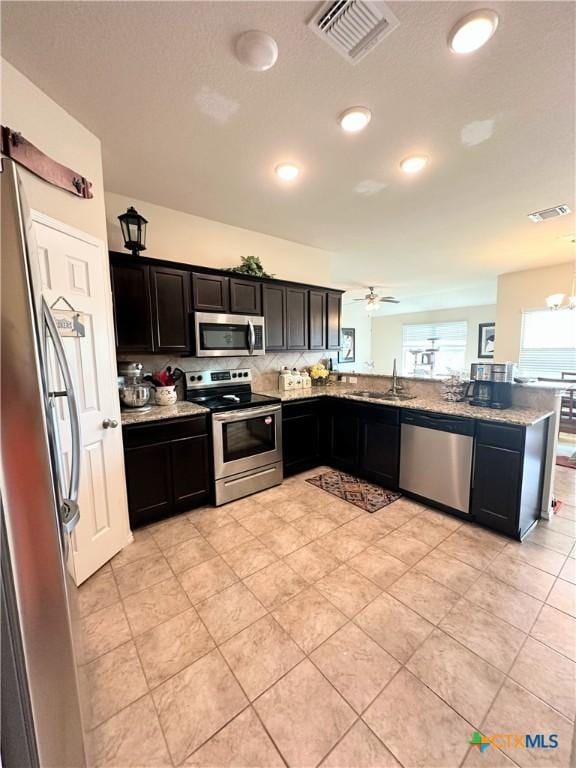 kitchen featuring dark cabinetry, visible vents, a sink, and appliances with stainless steel finishes