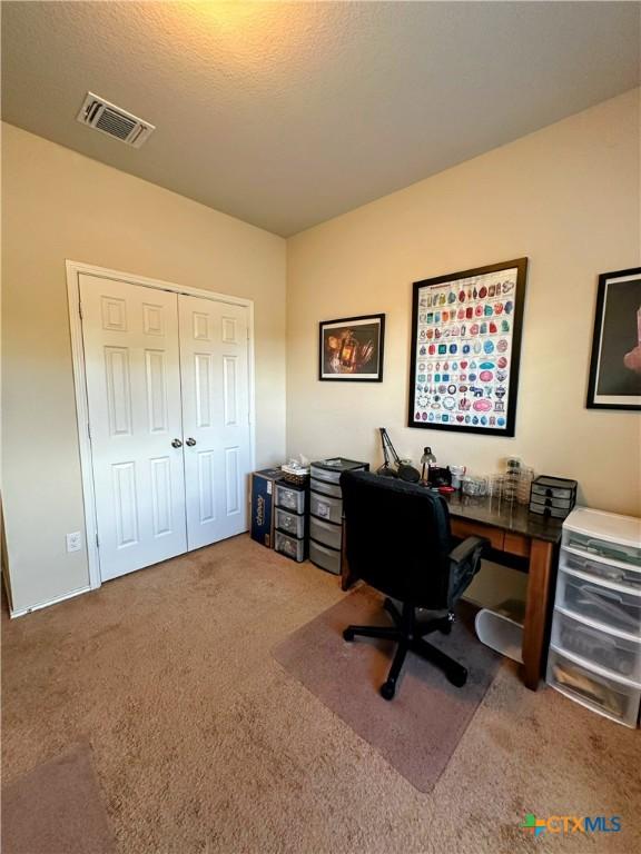 carpeted office space featuring visible vents