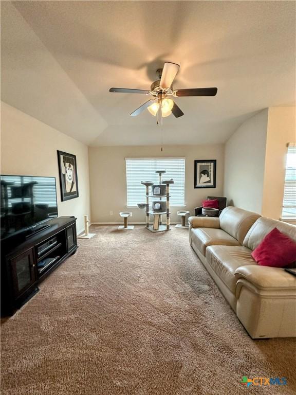 living area with carpet floors, a ceiling fan, and baseboards