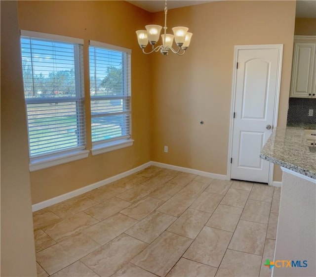 unfurnished dining area featuring a chandelier and light tile patterned floors