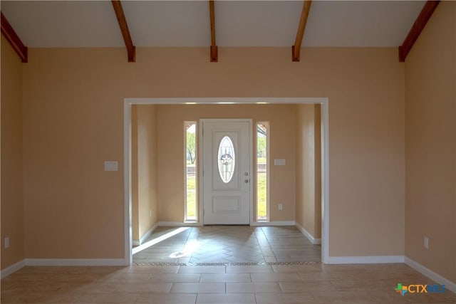 foyer featuring beamed ceiling and light tile patterned floors