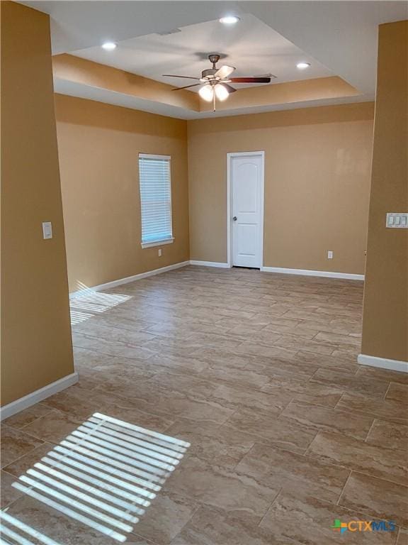 unfurnished room with a tray ceiling and ceiling fan