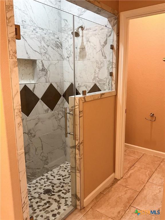 bathroom featuring tile patterned floors and an enclosed shower