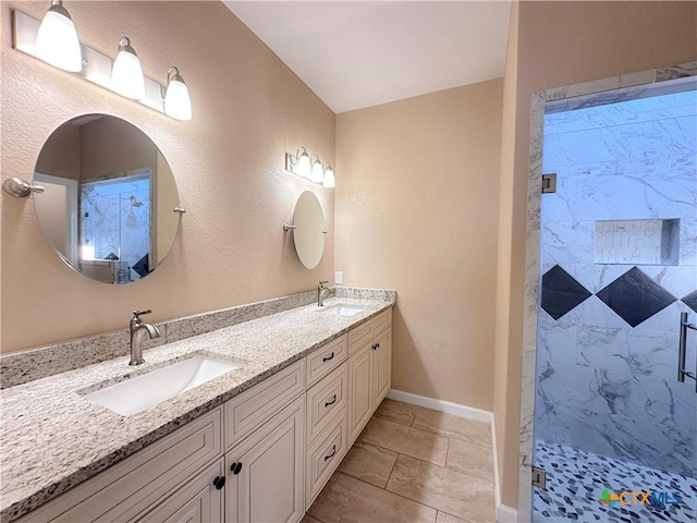 bathroom with tile patterned flooring, vanity, and a tile shower