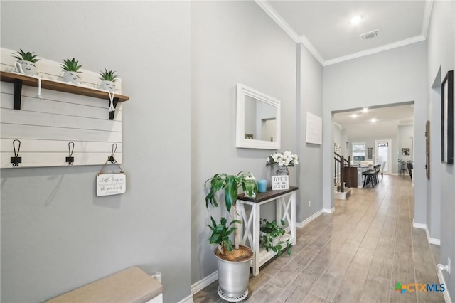 hallway with wood-type flooring and ornamental molding