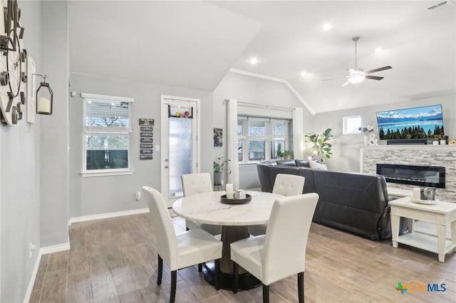 dining area with vaulted ceiling, a wealth of natural light, ceiling fan, and light hardwood / wood-style floors