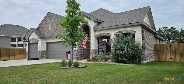 8302 Elander Dr, Killeen, TX 76542 - french country home with concrete driveway, brick siding, a garage, roof with shingles, and stone siding