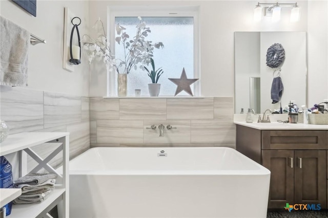 bathroom featuring vanity, a bathtub, and tile walls