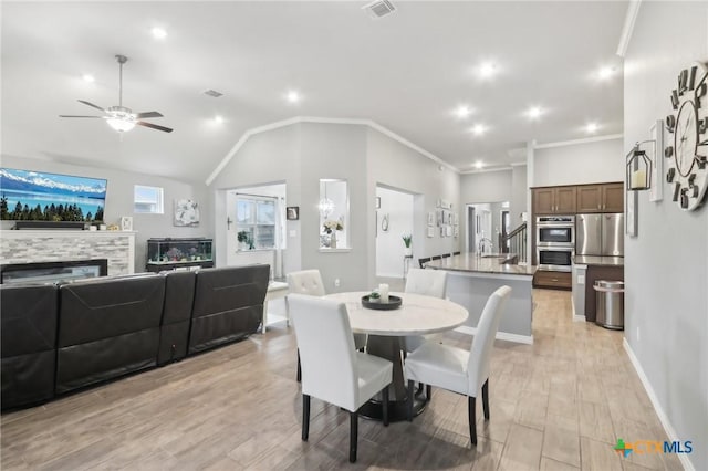 dining area featuring crown molding, ceiling fan, lofted ceiling, and light wood-type flooring