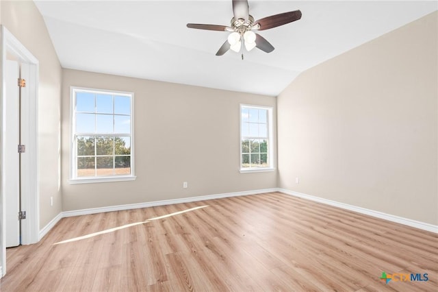 empty room with ceiling fan, vaulted ceiling, and light hardwood / wood-style flooring