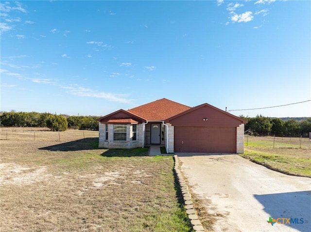 view of front of home featuring a rural view, a garage, and a front lawn