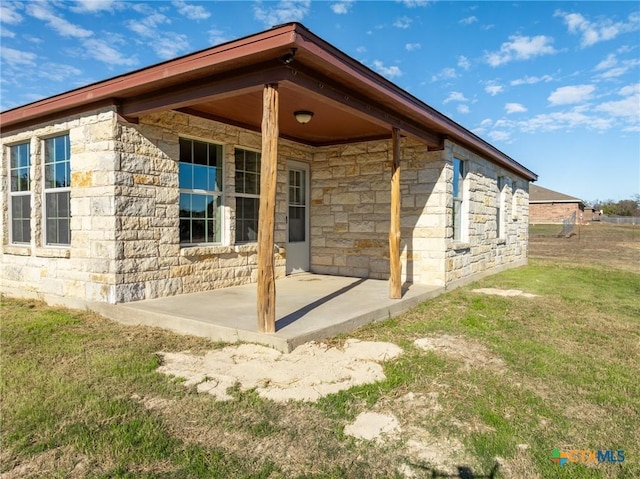 rear view of house with a lawn and a patio area