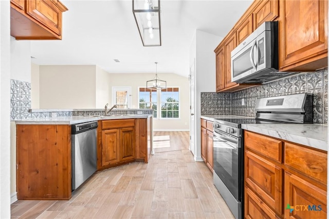 kitchen featuring light wood-type flooring, sink, appliances with stainless steel finishes, and tasteful backsplash