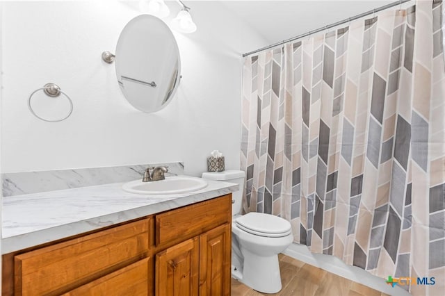 bathroom with wood-type flooring, vanity, toilet, and a shower with curtain