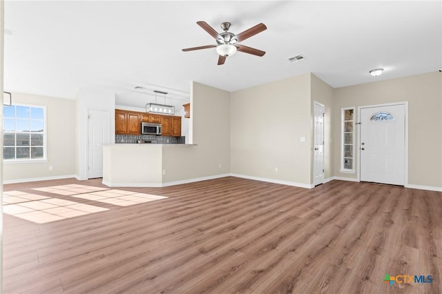 unfurnished living room with ceiling fan and light hardwood / wood-style floors