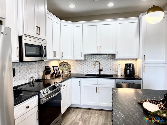 kitchen featuring stainless steel appliances, white cabinetry, and sink