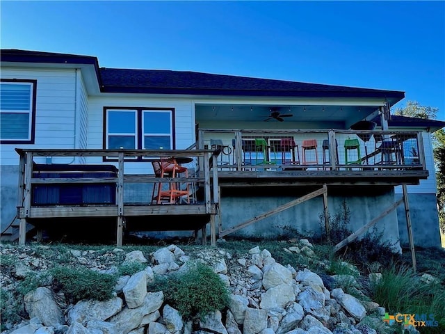 rear view of property with a wooden deck and ceiling fan