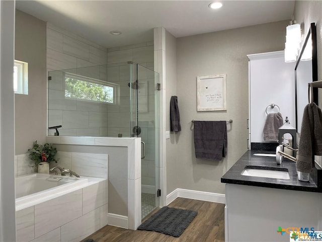 bathroom featuring hardwood / wood-style flooring, vanity, and separate shower and tub