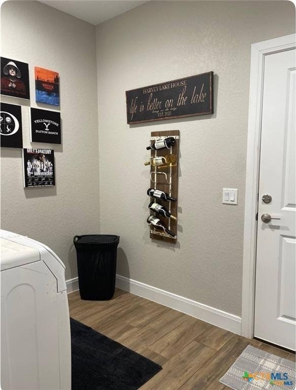 clothes washing area with wood-type flooring