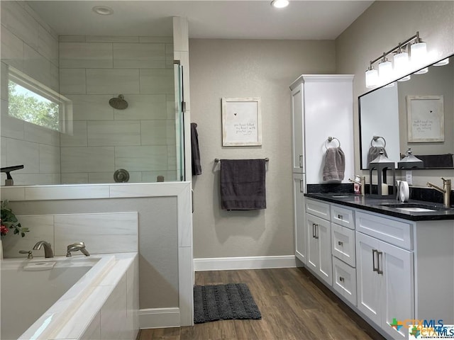 bathroom featuring independent shower and bath, vanity, and hardwood / wood-style floors