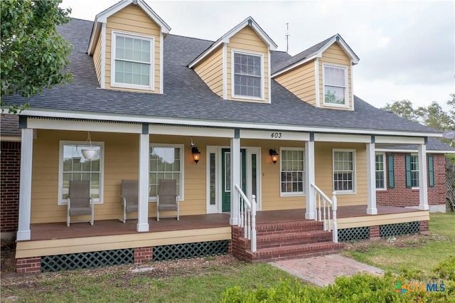 cape cod-style house with a porch and roof with shingles