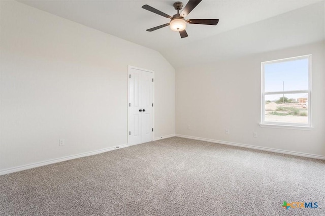 unfurnished room with vaulted ceiling, ceiling fan, and carpet flooring