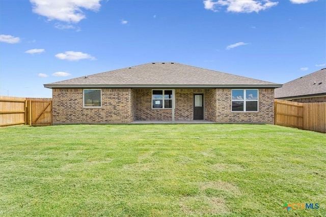 rear view of property featuring a lawn