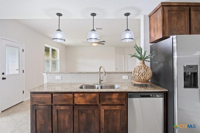 kitchen with tasteful backsplash, ceiling fan, sink, light stone countertops, and stainless steel appliances