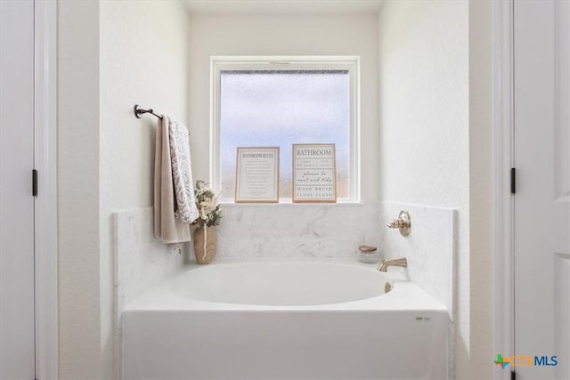 bathroom with a bathing tub and plenty of natural light