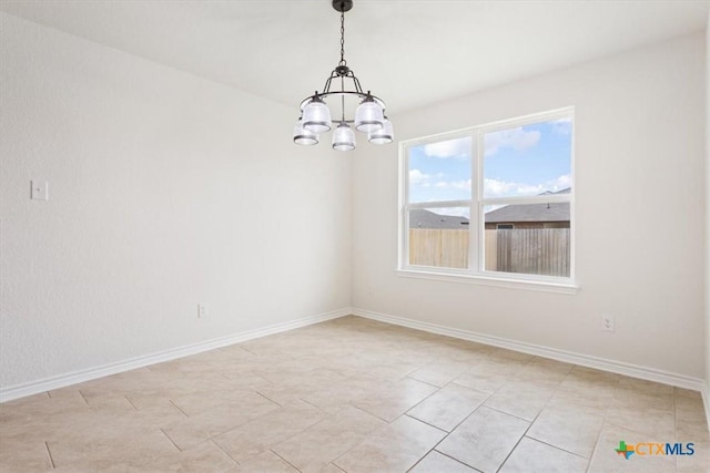 spare room featuring light tile patterned flooring and a notable chandelier