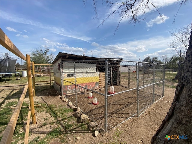 view of poultry coop featuring fence and a trampoline