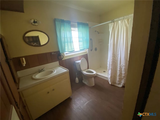 bathroom featuring toilet, vanity, wood finished floors, and a shower stall