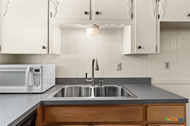 809 S 13th St, Copperas Cove, TX 76522 - kitchen featuring white microwave, a sink, dark countertops, dishwasher, and white cabinets