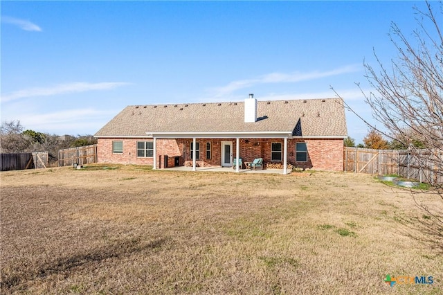 rear view of property featuring a yard and a patio