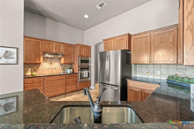 kitchen with stainless steel appliances, kitchen peninsula, sink, and backsplash