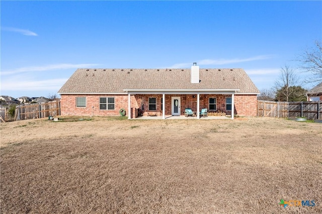 back of house featuring a lawn and a patio