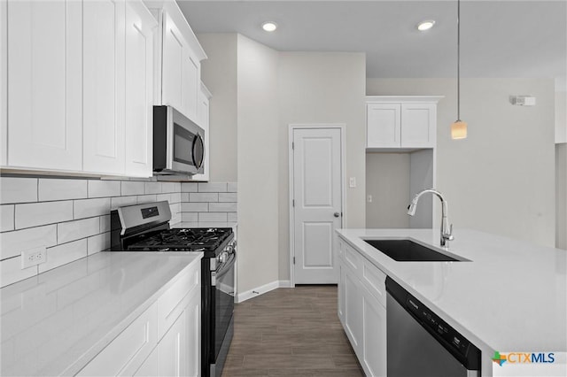 kitchen with sink, appliances with stainless steel finishes, hanging light fixtures, tasteful backsplash, and white cabinets