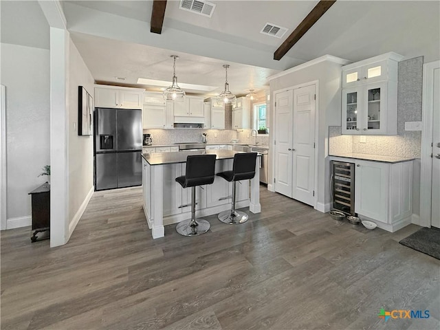 2237 Apache Dr, Harker Heights, TX 76548 - kitchen featuring fridge with ice dispenser, wine cooler, a kitchen island, backsplash, and white cabinetry