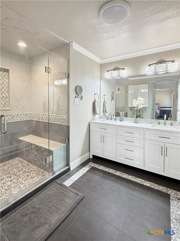 2237 Apache Dr, Harker Heights, TX 76548 - bathroom featuring ornamental molding, a shower stall, a textured ceiling, baseboards, and double vanity