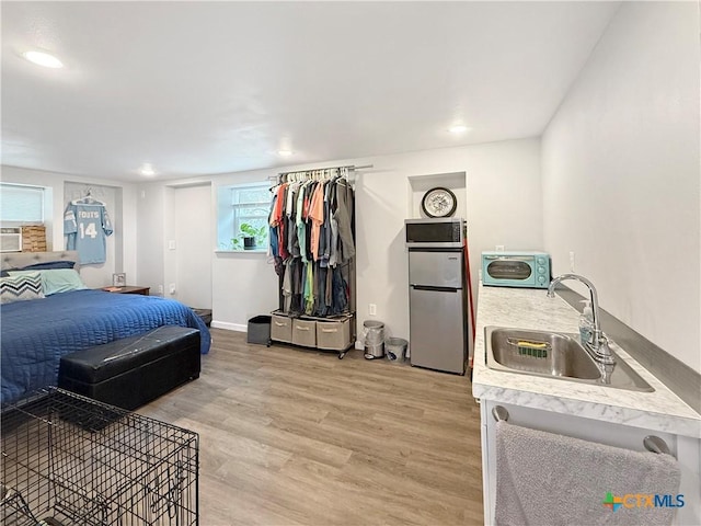 2237 Apache Dr, Harker Heights, TX 76548 - bedroom featuring freestanding refrigerator, a sink, light wood-style floors, baseboards, and recessed lighting