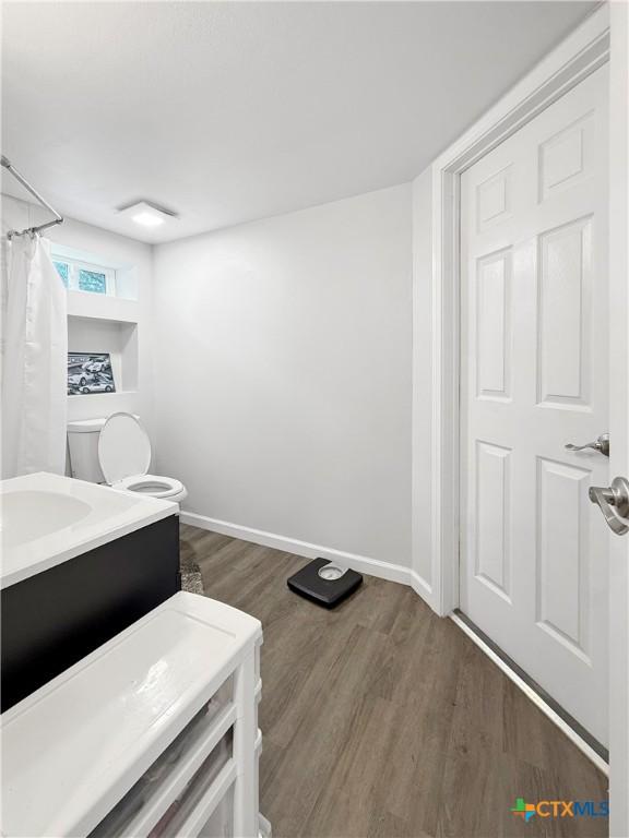 2237 Apache Dr, Harker Heights, TX 76548 - full bathroom with wood finished floors, toilet, vanity, and baseboards