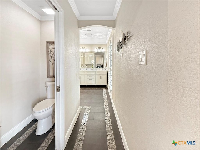 2237 Apache Dr, Harker Heights, TX 76548 - corridor featuring inlaid floor details, arched walkways, a textured wall, ornamental molding, and baseboards