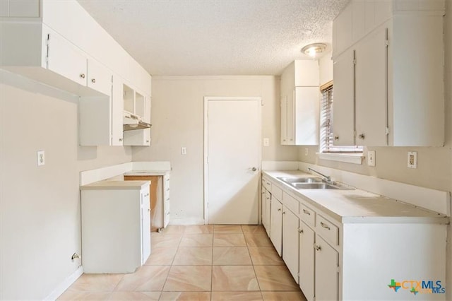 1009 S 29th St, Copperas Cove, TX 76522 - kitchen with a sink, a textured ceiling, under cabinet range hood, light countertops, and light tile patterned floors