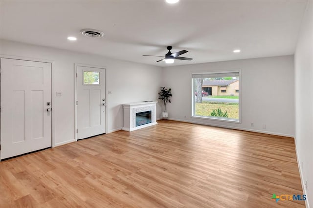 unfurnished living room with ceiling fan and light hardwood / wood-style flooring